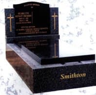 A dark granite double headstone and monument