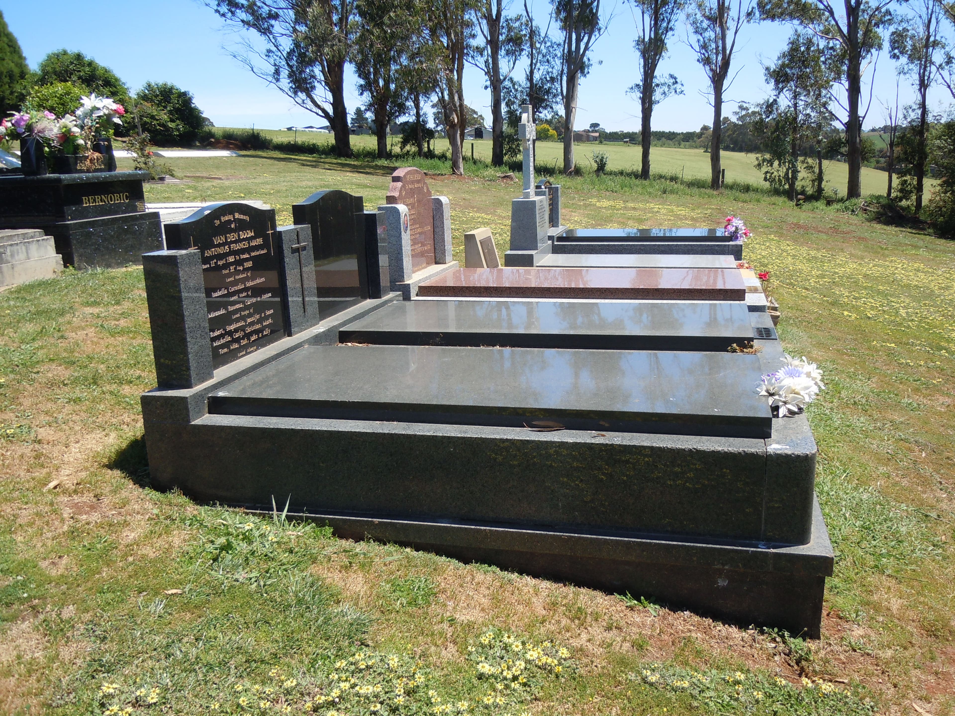 A monumental lawn grave with a cross-topped granite headstone