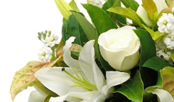 Close-up of a white lily and rose flower arrangement, alternate crop