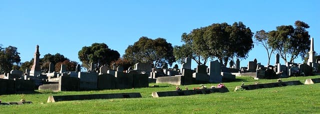 Rows of headstones and plaques in a cemetery