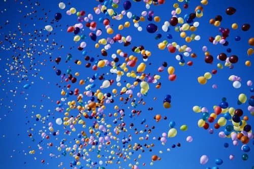 Balloons released into a clear blue sky
