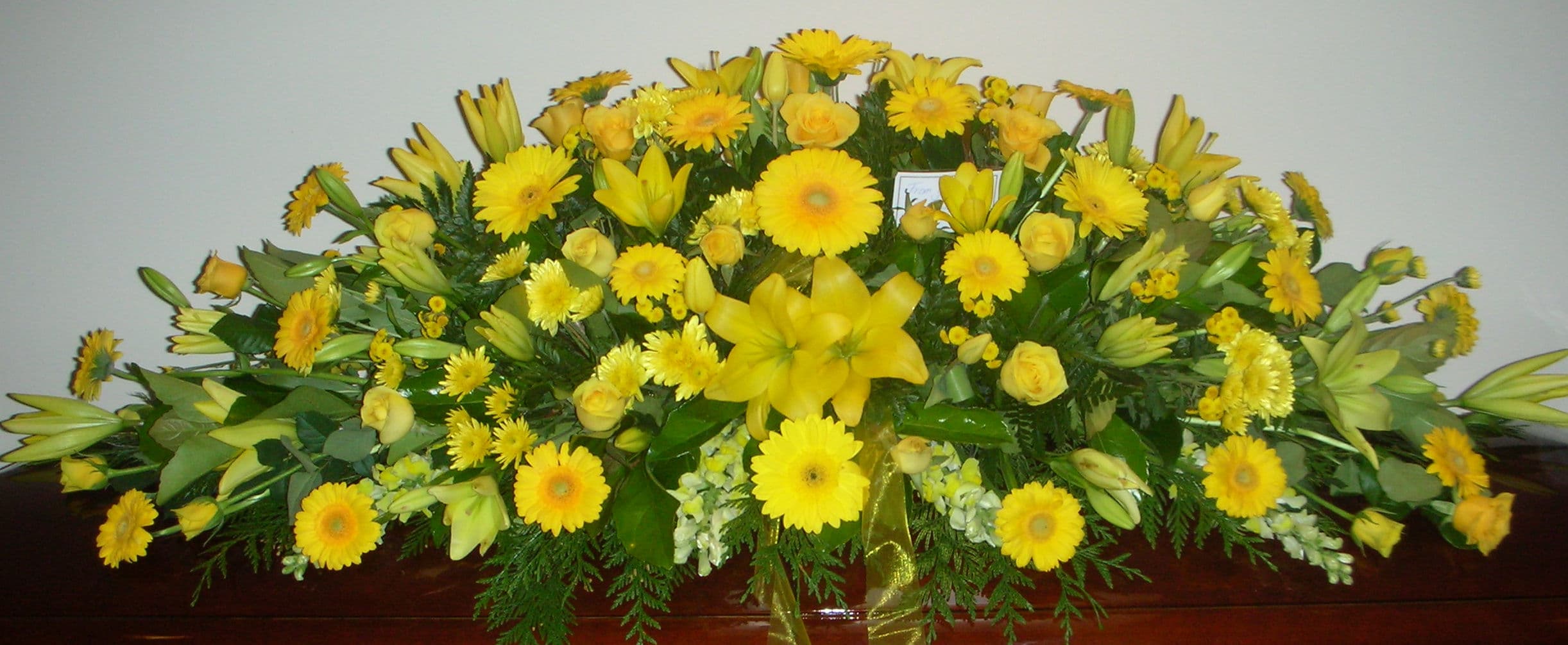 All yellow flower casket spray with lilies, gerberas and roses