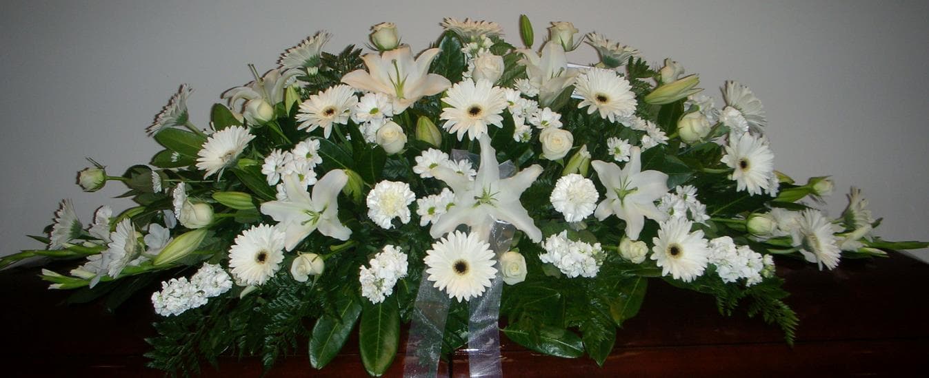 White flower casket spray with lilies, gerberas and roses
